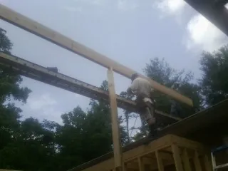 Carpenter setting a ridge beam over a new addition frame — Ice Dam Removal by Roofing Brothers in Luthersburg
