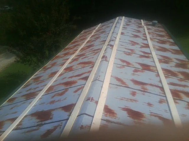 Rusted metal roof panels with new wood purlins before replacement — Storm Damage Roof Repair in Luthersburg by Roofing Brothers