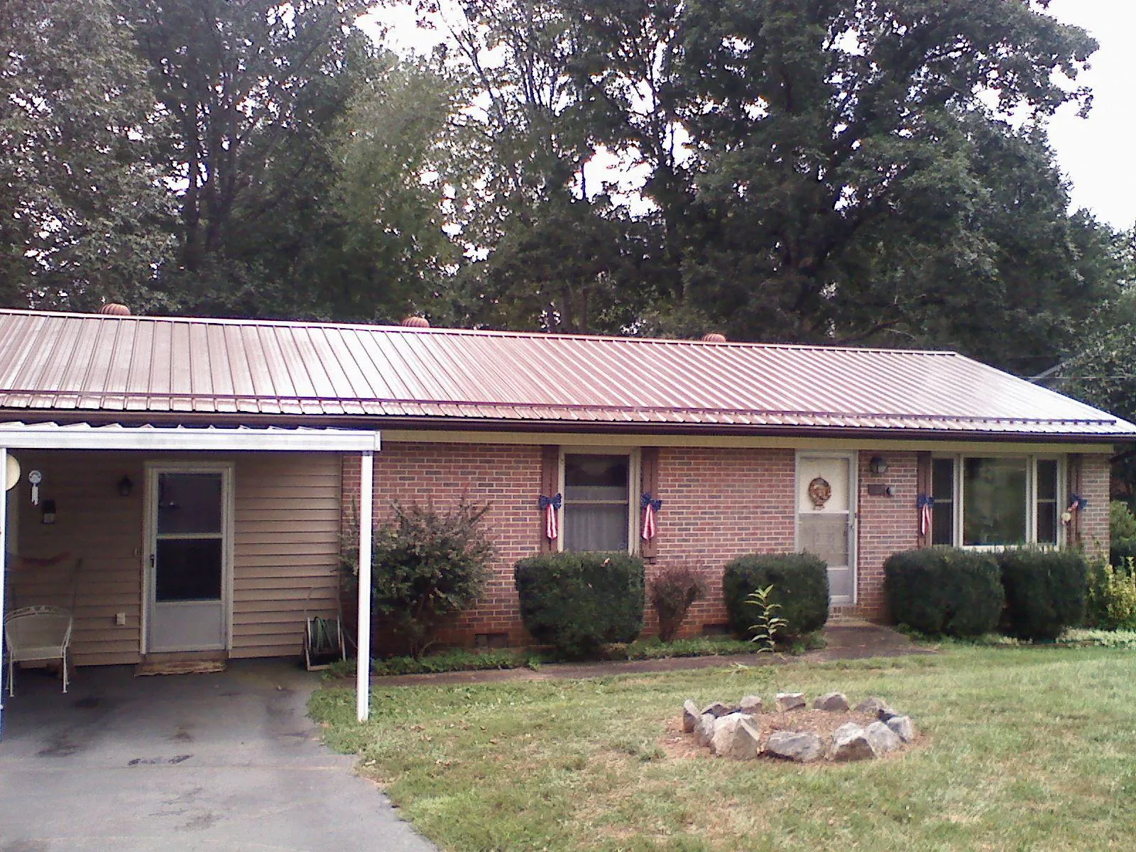 Bronze metal roof and carport on a brick ranch home — Roof Repair work by our crew in Luthersburg